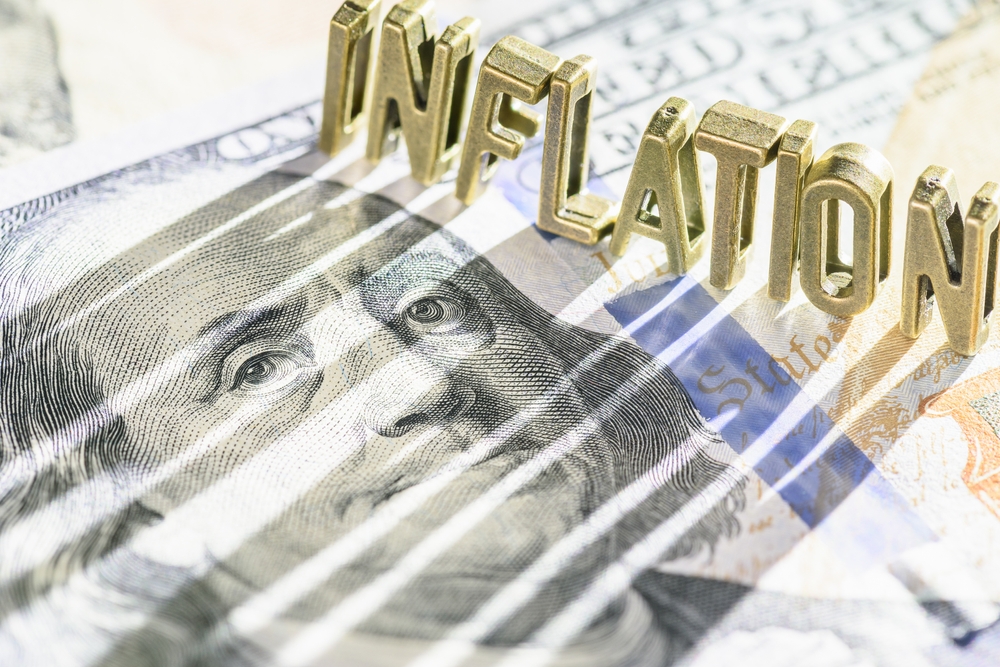 Inflation block letter casting shadow on $100 bill