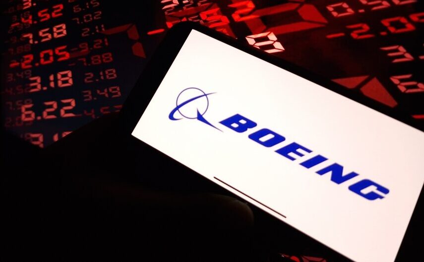 Boeing logo on cellphone in front of red market numbers